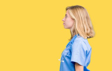 İzole arka tarafına, seyir üzerinde tıbbi üniforma giyen güzel genç doktor kadın dinlenmek doğal yüz emin gülümseme ile pozuyla profili.