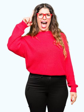 Kırmızı giyen genç güzel kadın başarılı fikirle işaret parmağı gözlük. Çıktıktan ve mutlu. Bir numara.