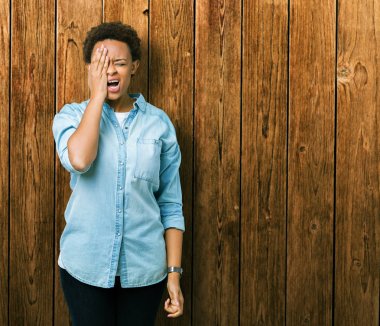 Genç güzel Afrikalı-Amerikalı kadın yarım yüz, göz ve ağız el ile kapsayan yorgun esneme izole arka plan yüzünden. Acı yüzü acıyor.