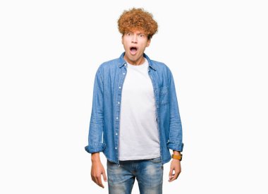 Şüpheci ve alaycı, arayan genç yakışıklı adam şok karşısında, denim ceket giyen afro saçlı açık ağız ile şaşırttı