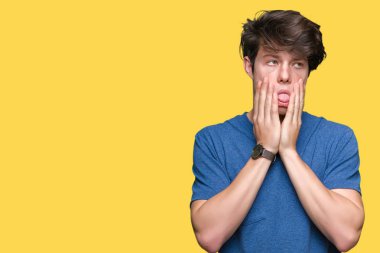 Yüz, depresyon ve üzüntü, kapsayan bıktınız eller izole arka plan üzerinde mavi t-shirt giyen genç yakışıklı adam üzgün ve sorun için tahriş