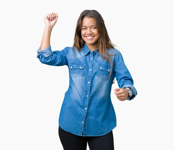 年轻美丽的黑发女人穿着蓝色粗斜纹棉布衬衫在孤立的背景跳舞快乐和欢快 微笑移动休闲和自信地听音乐 — 图库照片
