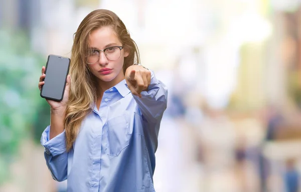 年轻美丽的金发女郎商业妇女显示屏幕智能手机在孤立的背景指向相机和你 正面和自信的手势从前面 — 图库照片