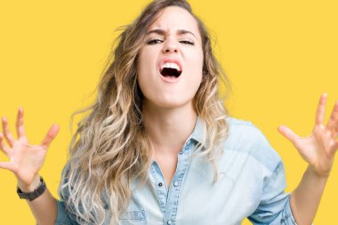 İzole arka plan çılgın ve kızgın bağırarak ve agresif ifade ve kaldırdı silah bağırmayı güzel sarışın genç kadın. Hayal kırıklığı kavramı.