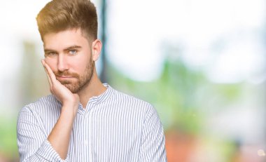 Yakışıklı delikanlı düşünme seyir yorgun ve sıkılmış çapraz silah depresyon sorunları ile.