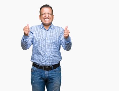 Orta yaş Arap iş adamı izole arka kolları olan başarı için heyecan üzerinde zafer kutluyor gülümseyen kaldırdı. Kazanan kavramı.