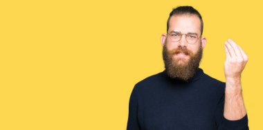 Gözlük ve kazak giyen genç sarışın adam el ve parmakları yla İtalyan jesti yapıyor kendinden emin ifadesi