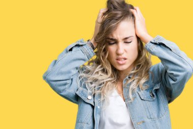 Çünkü çaresiz ve stresli baş ağrısı acı izole arka plan üzerinde kot ceket giyen güzel sarışın genç kadın acı ve Migren. Ellerini kafasına.