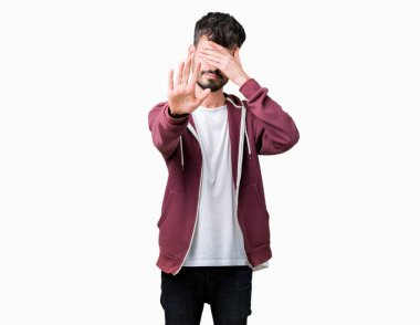 Genç yakışıklı adam izole elleriyle gözlerini kapsayan arka plan ve stop jest ile acı ve korku ifadesi. Utandım ve negatif kavramı.