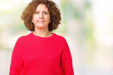 Güzel orta ager üst düzey kadın kırmızı kış kazak izole arka plan gevşek yüzünde ciddi bir ifade ile üzerinden. Basit ve doğal kameraya bakıyor.