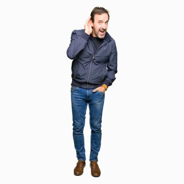 Orta yaş yakışıklı adam bir işitme söylenti ya da dedikodu için dinleme kulak üzerinde el ile gülümseyen bir ceket giyiyor. Sağırlık kavramı.
