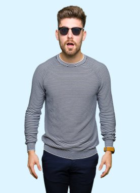 Yakışıklı delikanlı korkuyor ve şok sürpriz ifade, korku ve heyecan yüz ile güneş gözlüğü takıyor.