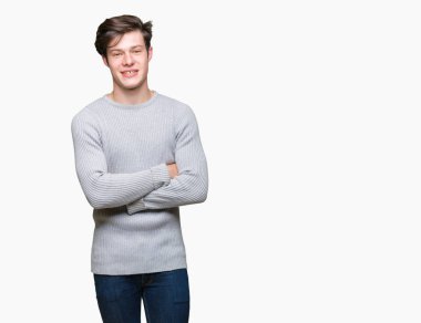 Mutlu yüz ile gülümseyerek kameraya seyir silah geçti arka plan üzerinde kış kazak giyen genç yakışıklı adam izole. Olumlu bir kişi.