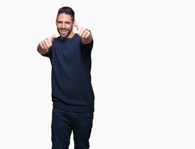 El ile pozitif jest yapıyor onaylama izole arka plan üzerinde kazak giyen genç yakışıklı adam başparmak gülümseyen ve başarı için mutlu. Kamera, kazanan jest arıyorsunuz.