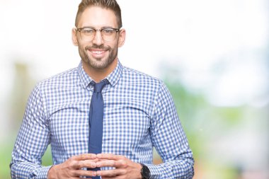 Arka plan eller birlikte üzerinde gözlük takan genç iş adamı izole ve rahat ve neşeli gülümseyen parmak çarpı işareti. Başarı ve iyimser