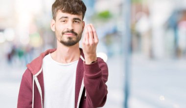 Yakışıklı delikanlı izole arka plan üzerinde yapıyor İtalyan jest el ve parmak emin ifadesiyle