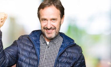 Orta yaş yakışıklı adam kış ceket giyen Güçlü kişi kol kas gösteren, kendine güvenen ve güç gurur