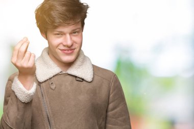 İzole arka plan üzerinde kış ceket giyen genç yakışıklı adam el ve parmaklar emin ifade ile Italyan jest yapıyor