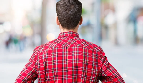 İzole arka plan ayakta geriye doğru uzakta silah ile vücut üzerinde seyir üzerinde gözlük takan genç yakışıklı adam