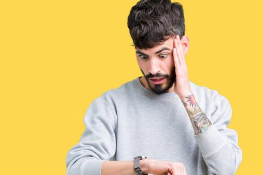 Üzerine tişört giyen genç yakışıklı adam arka plan izole seyretmek zaman endişeli, geç korkuyor arıyorsunuz