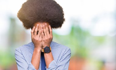 Afro saçlı gözlüklü yüz eller ile ağlayarak süre kapsayan üzgün ifade ile genç Afro-Amerikalı iş adamı. Depresyon kavramı.