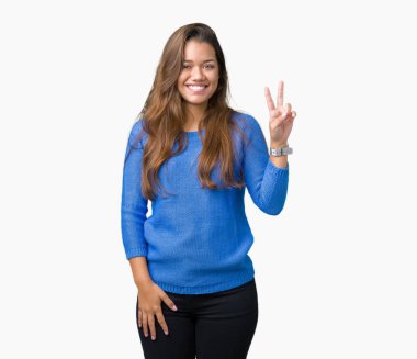 Üzerinde gösterilen ve parmakları ile işaret izole arka plan mavi kazak giyen genç güzel esmer kadın ikincisi ise kendinden emin ve mutlu gülümseyerek.