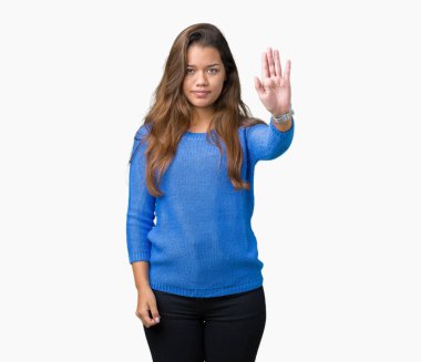 Stop yapıyor izole arka plan üzerinde mavi kazak giyen genç güzel esmer kadın elin avuç ile şarkı. Negatif ve ciddi bir jest yüz ifadesiyle uyarı.