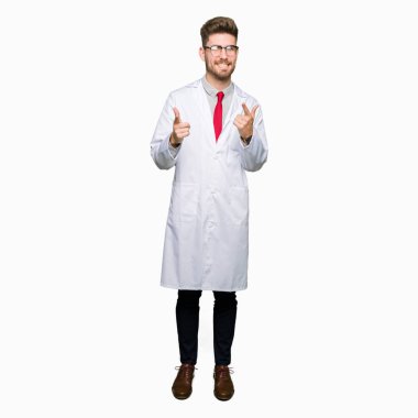 Fotoğraf makinesi ile mutlu ve komik yüz için parmakları işaret gözlüklü genç yakışıklı bilim adam. İyi enerji ve vibes.