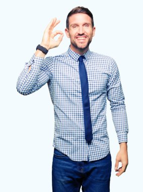 Yakışıklı iş adamı giyen kravat el ve parmaklar ok işaretiyle yapıyor olumlu gülümseyerek. Başarılı ifade.