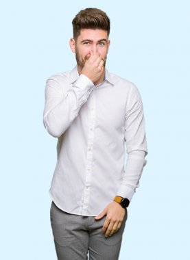 Genç yakışıklı iş adamı bir şey pis ve iğrenç kokulu, dayanılmaz koku, umutla parmaklarıyla burnuna. Kötü kokuyor kavramı.