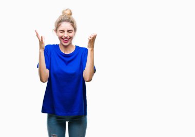 Kızgın ve silah ile başarı için deli izole arka plan kutluyor üzerinde mavi t-shirt giyen genç güzel sarışın ve mavi gözlü kadın kaldırdı ve heyecanlı çığlık gözler kapalı. Kazanan kavramı