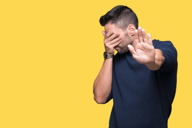 Yakışıklı delikanlı üzerinde kazak giyen izole elleriyle gözlerini kapsayan arka plan ve dur jest ile acı ve korku ifadesi. Utandım ve negatif kavramı.