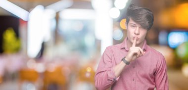 Genç yakışıklı iş adamı dudaklarında parmak ile sessiz olmanı izole arka plan üzerinde. Sessizlik ve gizli kavramı.