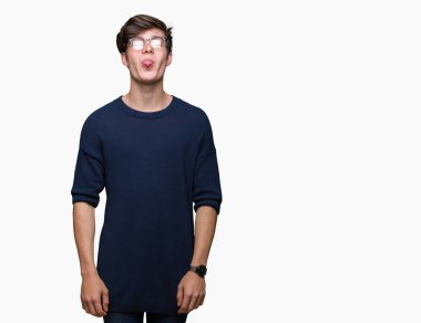 Genç yakışıklı adam gözlük dilini izole arka plan üzerinde mutlu komik ifade ile dışarı. Duygu kavramı.