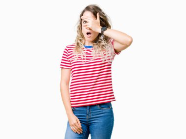 Yüz ve gözler el ile kapsayan şok bakmak izole arka plan üzerinde güzel genç sarışın kadın mahcup ifadeyle parmaklarımın arasından arıyorsunuz.