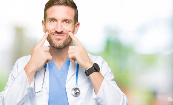 分離の上医療制服を着てハンサムな医者の男は口を開けて 笑顔をバック グラウンド指を指すし 陽気な笑顔 — ストック写真