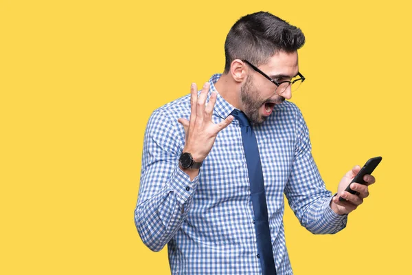Genç iş adamı smartphone üzerinde kullanma büyük gülümseme ile çığlık zaferini kutluyor arka plan çok mutlu ve heyecanlı, kazanan ifade izole ve ellerini kaldırdı