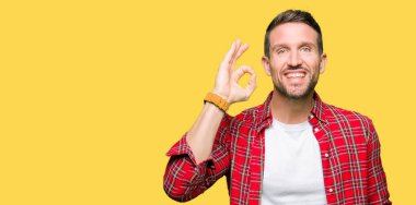 El ve parmak ile ok işareti yapıyor olumlu gülümseyen rahat gömlek giymiş yakışıklı adam. Başarılı ifade.