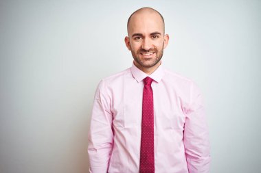 Genç iş adamı yüzünde mutlu ve serin bir gülümseme ile izole arka plan üzerinde pembe kravat giyiyor. Şanslı kişi.