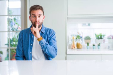 Evde ki yakışıklı adam, parmak dudaklarında sessiz olmak istiyor. Sessizlik ve gizli kavram.