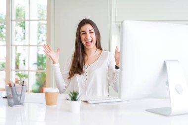 Bilgisayar kullanarak çalışan genç kadın deli kutluyor ve kollarını kaldırdı ve açık gözleri ile başarı için hayran heyecanlı çığlık. Kazanan kavramı