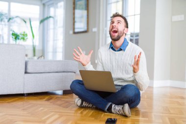 Yakışıklı adam bilgisayar dizüstü bilgisayar deli ve deli kullanarak çalışan giyen ve agresif ifade ve kollar kaldırdı ile bağırıyor. Hayal kırıklığı kavramı.