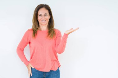 Neşeli sunulması ve kameraya bakarak avucunun ile işaret gülümseyen izole arka plan güzel orta yaş kadın.