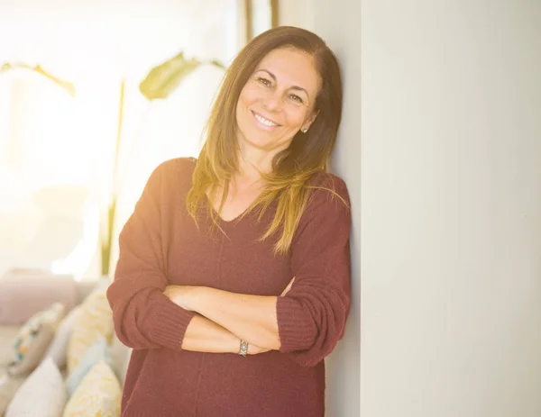 Beautiful middle age woman smiling with crossed arms at home — Stock Photo, Image