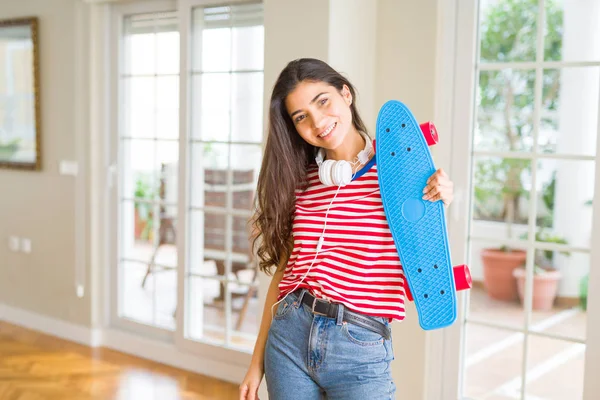 Schöne Skaterin freundlich lächelnd mit Skateboard stehend — Stockfoto