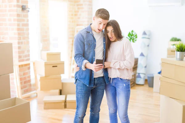 Bela Jovem Casal Mudando Para Uma Nova Casa Usando Smartphone — Fotografia de Stock