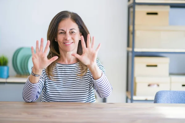 Mujer Mayor Mediana Edad Sentada Mesa Casa Mostrando Señalando Hacia —  Fotos de Stock