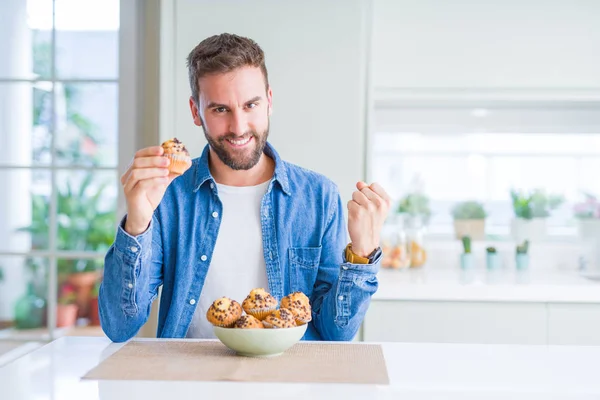 Hombre Guapo Comiendo Chips Chocolate Muffin Gritando Orgulloso Celebrando Victoria — Foto de Stock