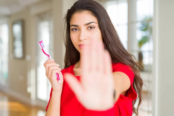 Młoda Kobieta Trzyma Dentystyczne Szczoteczki Otwartą Ręką Robi Znak Stop — Zdjęcie stockowe