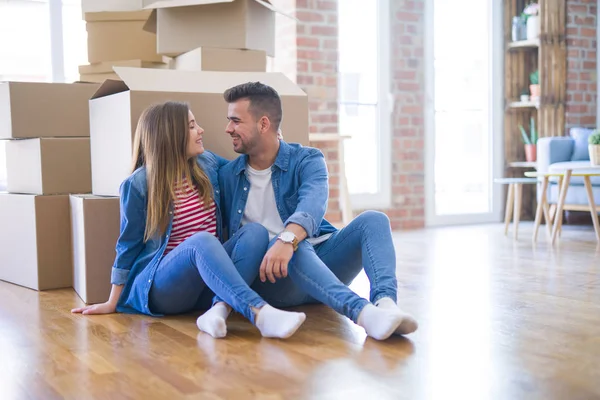 Young beautiful couple in love moving to new home, sitting on th — Stock Photo, Image